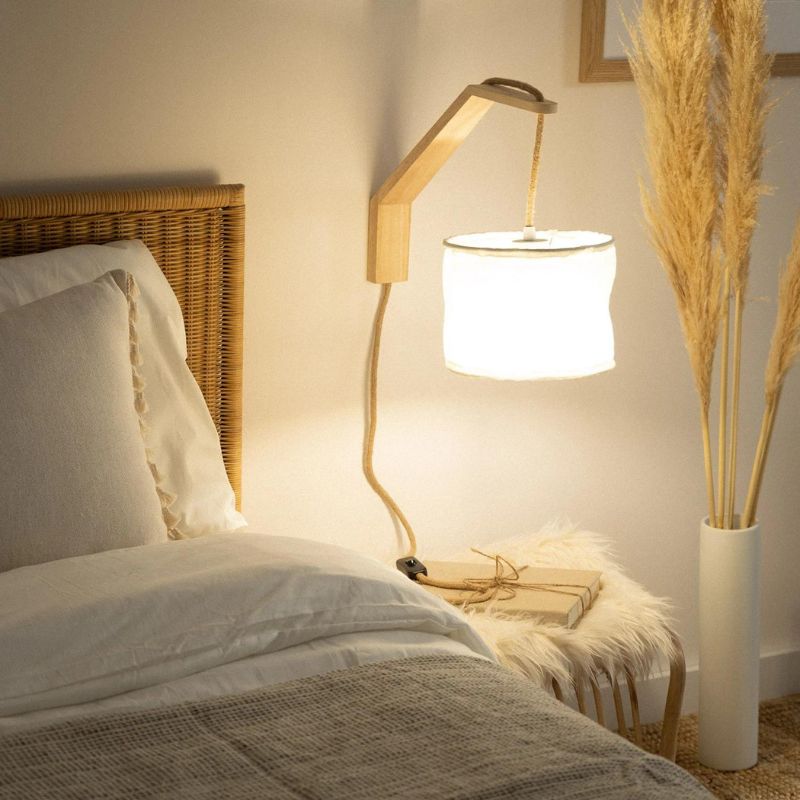 lampe de chevet equerre bois allumée dans la chambre à coucher