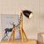 lampe de chevet moderne bois girafe vert allumée sur une table