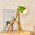 lampe de chevet moderne bois girafe vert allumée sur une table
