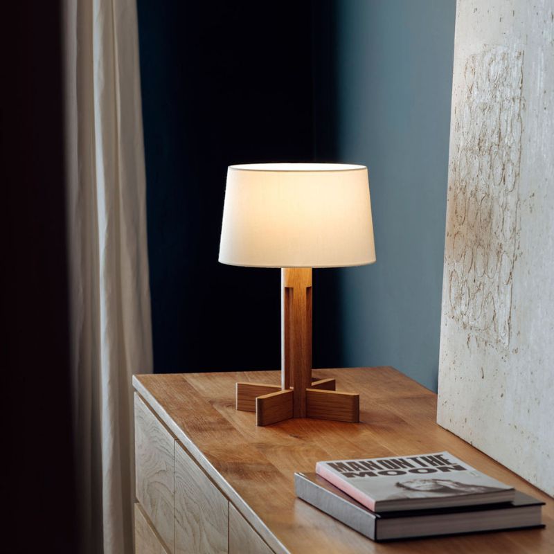 Lampe de chevet vintage bois à poser allumée sur un meuble en bois