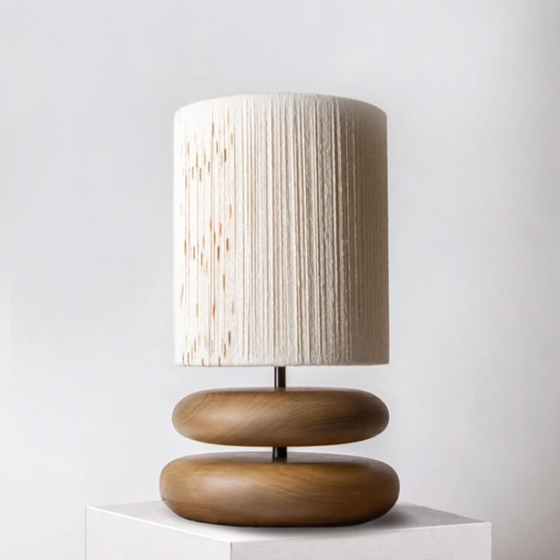 Lampe de chevet en bois d'acacia allumée sur un meuble de salon