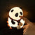 Doigt qui touche le nez de la veilleuse panda lumineux