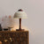 lampe de chevet bois flotté artisanal allumée sur un meuble