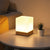 lampe de chevet cube bois allumée sur une table ronde