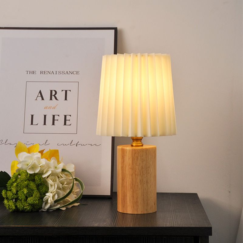 lampe de chevet design bois scandinave clair allumée sur un meuble noir
