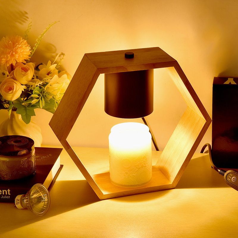 lampe de chevet en bois naturel hexagone allumée sur un bureau