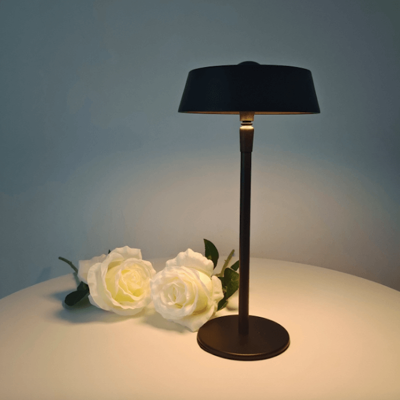 lampe de chevet tactile sans fil design sur une table a coté des fleurs