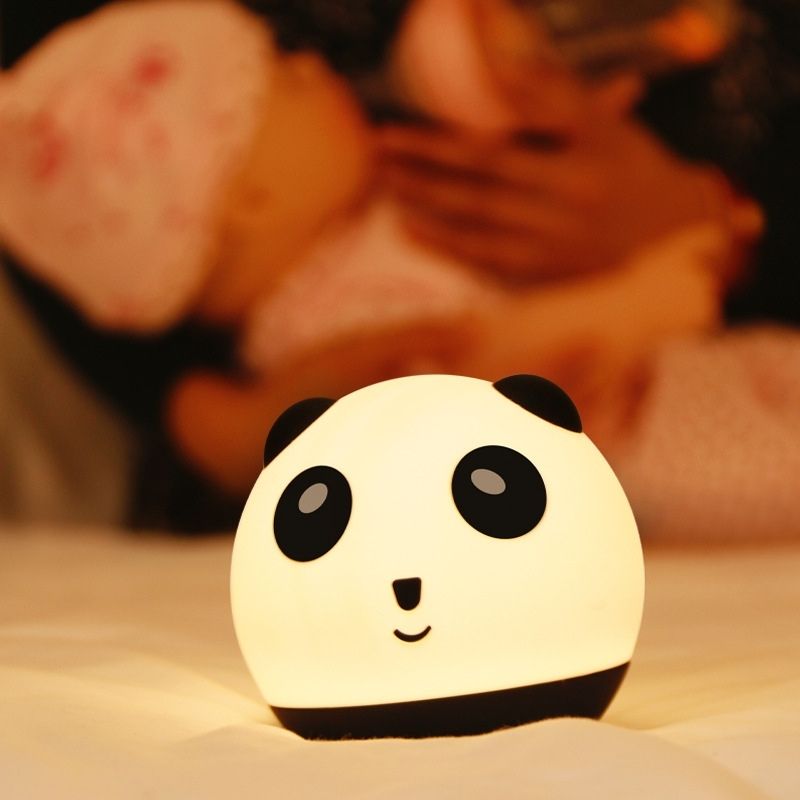 La lampe veilleuse panda allumée sur un lit