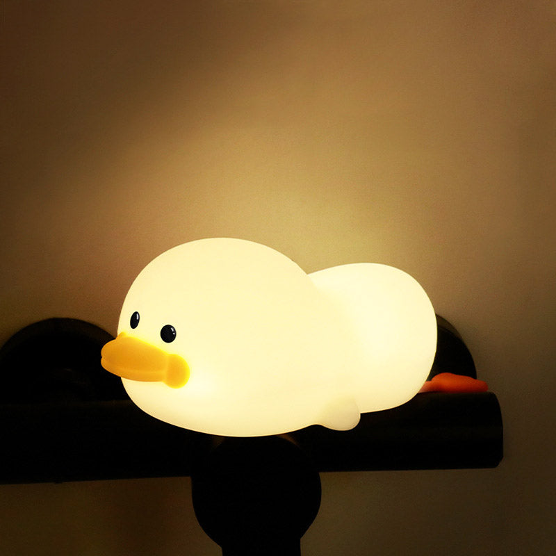 Veilleuse canard posée sur le rebord d'un lit