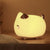 Veilleuse chat rechargeable allumée sur une table de chevet